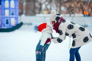 retrato de menina adorável e jovem mãe patinando foto