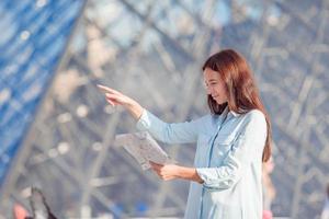 jovem mulher com mapa na cidade europeia ao ar livre foto