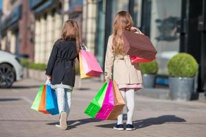 menina da moda com sacolas de compras ao ar livre na cidade grande foto