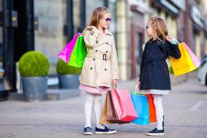 adoráveis meninas em compras. retrato de crianças com sacolas de compras. foto