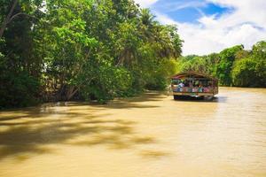 barco de cruzeiro exótico com turistas em um rio de selva loboc, bohol foto