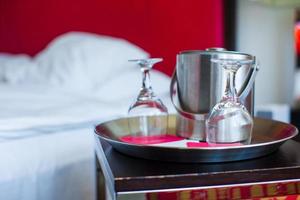 quarto romântico com taças de vinho no interior do hotel de luxo foto