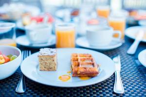 salada de frutas frescas, waffles, bolo, café e suco servido no café da manhã no restaurante do resort foto