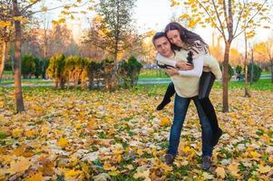 casal feliz se divertindo no parque outono em um dia ensolarado de outono foto