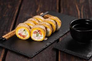 rolo com sushi de peixe com pauzinhos - conceito de comida japonesa asiática foto