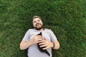 homem com gatinho deitado e brincando na grama - animais de amor de amizade e conceito de dono de animal de estimação foto