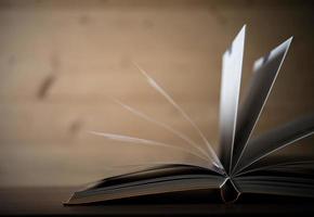 close-up de um livro aberto em uma mesa de madeira foto