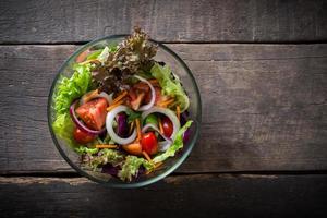 salada de legumes fresca em fundo de madeira foto