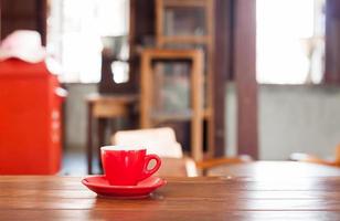 xícara de café vermelha em uma mesa de madeira foto