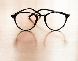 óculos em uma mesa de madeira foto