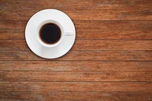 xícara de café branco em uma mesa de madeira foto