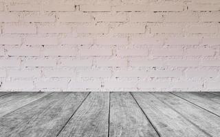 mesa de madeira cinza contra parede de tijolo branco foto