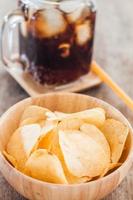 close-up de uma tigela de batatas fritas com coca-cola gelada foto