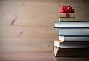 caixa de presente e livros na mesa de madeira foto