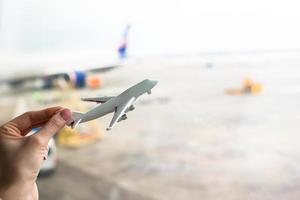 fechar a mão segurando um modelo de avião no aeroporto foto