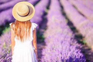 mulher no campo de flores de lavanda em vestido branco e chapéu foto