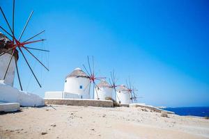 vista famosa dos moinhos de vento gregos tradicionais na ilha de mykonos ao nascer do sol, cyclades, grécia foto