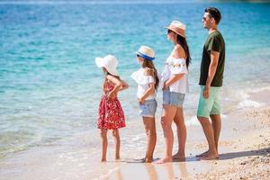 família linda feliz com crianças na praia foto