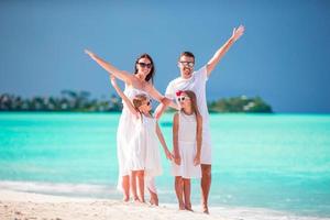 família jovem em férias na praia foto