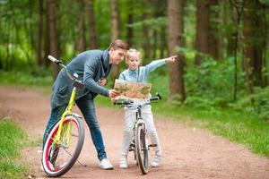 família feliz andando de bicicleta ao ar livre no parque foto