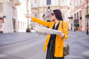 jovem mulher com um mapa da cidade na cidade. menina turista de viagens com mapa em viena ao ar livre durante as férias na europa. foto