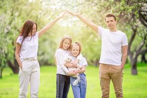 família adorável no jardim cerejeira florescendo em lindo dia de primavera foto