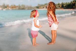 garotinhas engraçadas felizes se divertem muito na praia tropical brincando juntas. foto