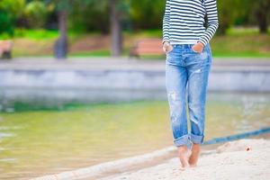 jovem mulher feliz andando perto do lago no dia quente de outono foto