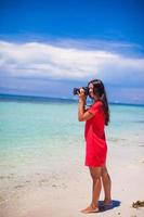 perfil de jovem simpática fotografou bela paisagem marítima na praia de areia branca foto
