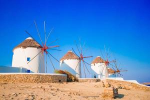 vista famosa dos moinhos de vento gregos tradicionais na ilha de mykonos ao nascer do sol, cyclades, grécia foto