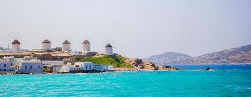 panorama da famosa vista dos tradicionais moinhos de vento gregos na ilha de mykonos ao nascer do sol, cyclades, grécia foto