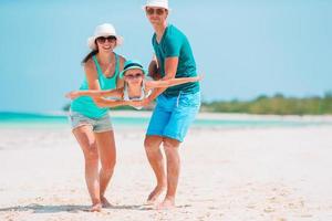 jovem família na praia branca durante as férias de verão foto