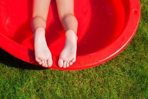 close-up das pernas de uma menina na piscina foto