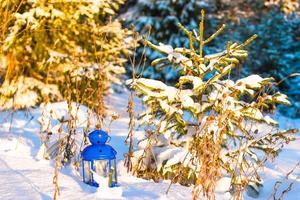 lanterna azul com uma vela na neve branca ao ar livre foto