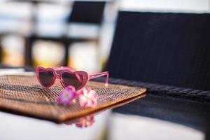 óculos de sol de crianças closeup em cima da mesa no resort tropical foto
