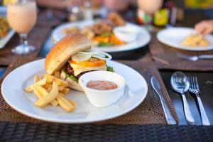 hambúrguer e batatas fritas na chapa branca para o almoço foto