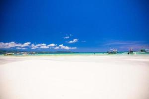 praia tropical perfeita com água turquesa, areia branca e veleiros foto