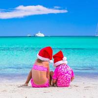 meninas em gorros de Papai Noel durante as férias de verão foto