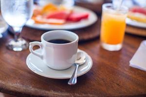 café preto, suco e frutas no café da manhã em um café no resort exótico foto