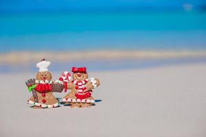 biscoitos de homem-biscoito de natal em uma praia de areia branca foto