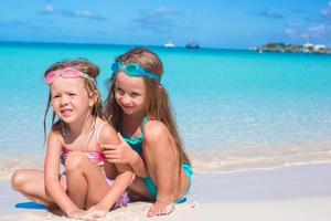 adoráveis meninas em traje de banho e óculos para nadar na praia foto