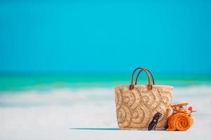 acessórios de praia - bolsa, chapéu de palha, óculos de sol na praia branca foto