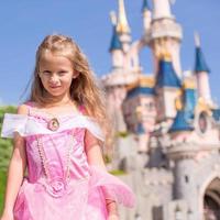 menina adorável em lindo vestido de princesa no parque de conto de fadas foto