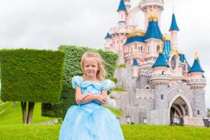 menina adorável em lindo vestido de princesa no parque de conto de fadas foto