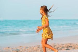 adorável menina se divertir na praia tropical durante as férias foto