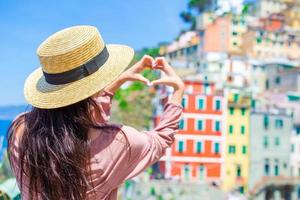 mulher bonita com vista incrível da vila italiana na rua velha em cinque terre, itália foto