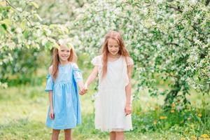 adoráveis meninas no jardim de macieiras florescendo na primavera foto