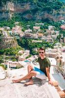 férias de verão na Itália. jovem na vila de positano ao fundo, costa amalfitana, itália foto