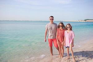 família linda feliz em umas férias de praia tropical foto