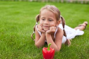 menina adorável com prato de legumes no jardim foto